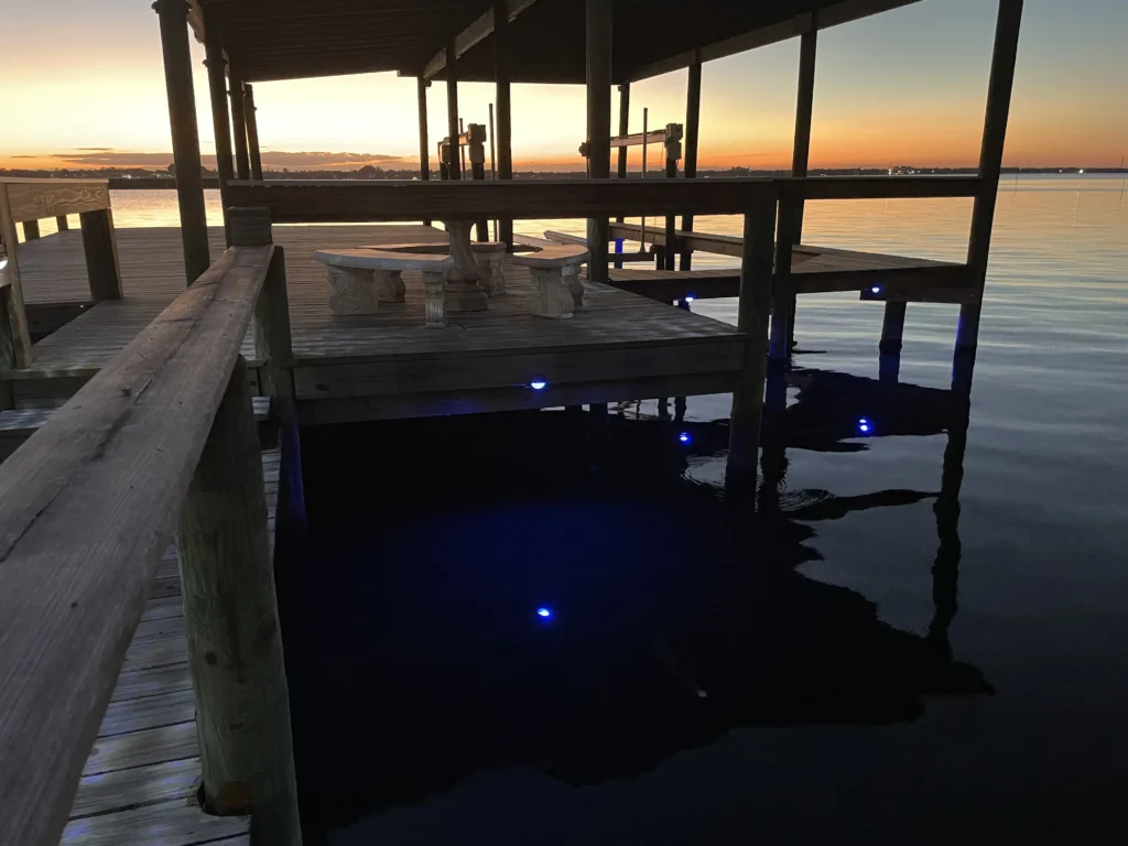 Illuminated boat dock with underwater LED lights at sunset in Brevard County FL